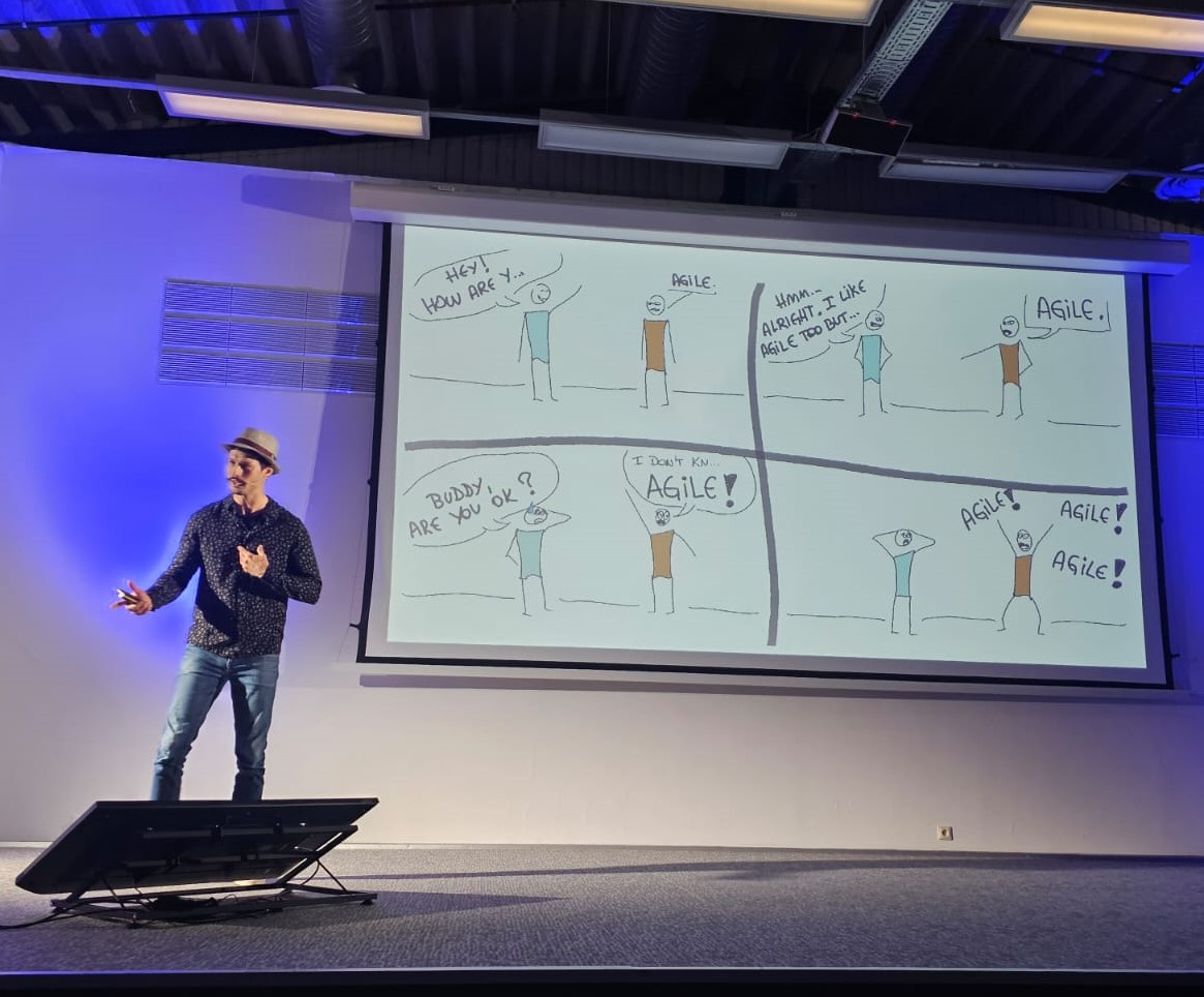 Artur presenting the Agile Allergy keynote with cartoons on screen